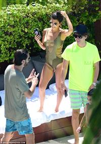 Kourtney Kardashian captured attention wearing a hot lace-up swimsuit and allowing onlookers to get a good view of her cleavage and narrow waistline.