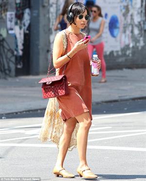 Zoe Kravitz walking in shorts and an orange top