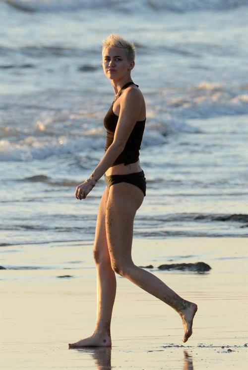 Miley Cyrus  yoga in black bikini on beach in Hawaii 1/24/13 