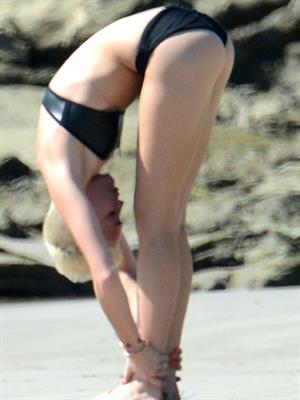 Miley Cyrus  yoga in black bikini on beach in Hawaii 1/24/13 