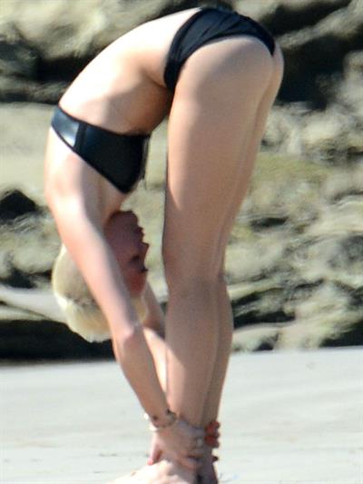 Miley Cyrus  yoga in black bikini on beach in Hawaii 1/24/13 