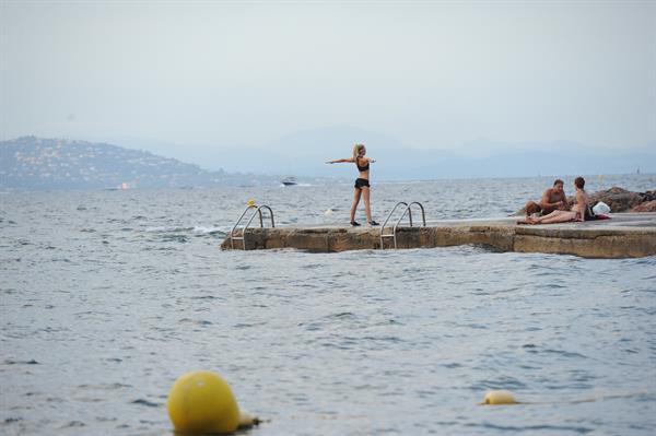 Kimberley Garner in a black bikini on the beach in St. Tropez on July 31, 2014