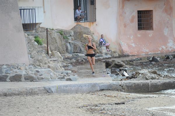 Kimberley Garner in a black bikini on the beach in St. Tropez on July 31, 2014