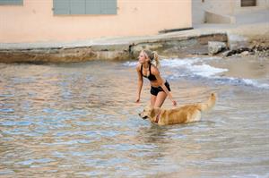 Kimberley Garner in a black bikini on the beach in St. Tropez on July 31, 2014