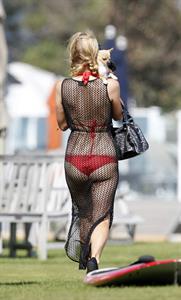 Paris Hilton at the beach in a skimpy red bikini and fishnet kaftan in Malibu.July 12, 2013