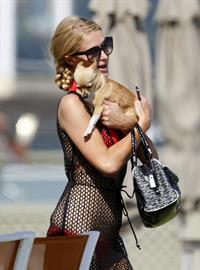 Paris Hilton at the beach in a skimpy red bikini and fishnet kaftan in Malibu.July 12, 2013