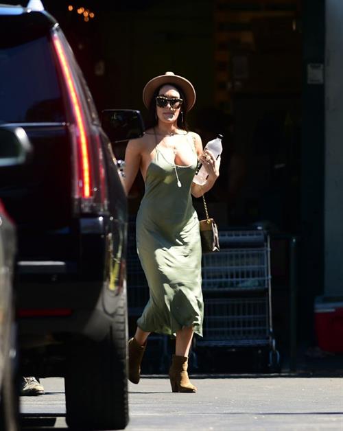 Nikki Bella Pictures Nikki Bella braless boobs in a green dress seen by paparazzi.