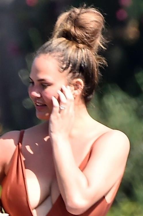 Chrissy Teigen sexy cleavage and ass in a swimsuit with her husband John Legend seen by paparazzi.
