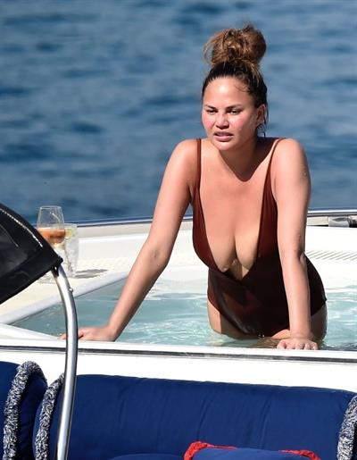 Chrissy Teigen sexy cleavage and ass in a swimsuit with her husband John Legend seen by paparazzi.
