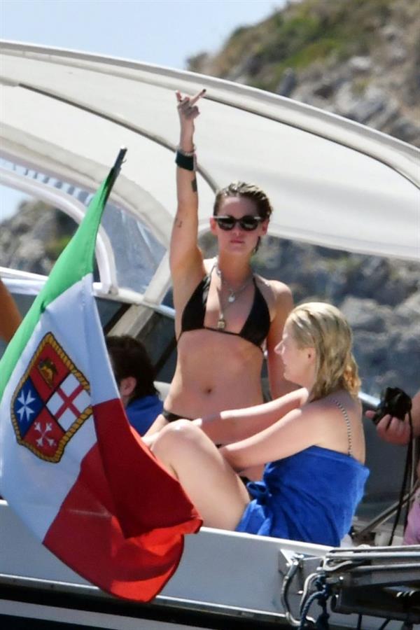Kristen Stewart nude boobs caught topless by paparazzi tanning on a boat.

