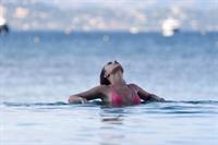 Kimberley Garner sexy model body in a pink bikini at beach seen by paparazzi.




