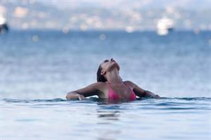 Kimberley Garner sexy model body in a pink bikini at beach seen by paparazzi.




