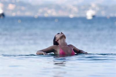 Kimberley Garner sexy model body in a pink bikini at beach seen by paparazzi.




