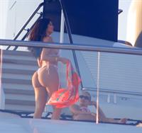 Kylie Jenner sexy ass in a thong bikini also showing nice cleavage seen by paparazzi on her super yacht.
