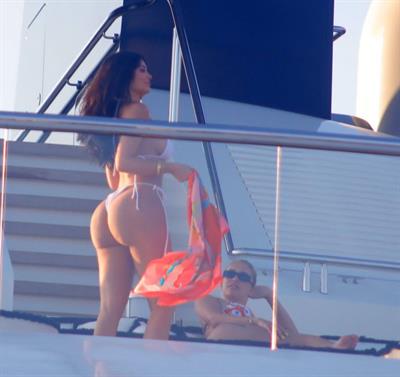 Kylie Jenner sexy ass in a thong bikini also showing nice cleavage seen by paparazzi on her super yacht.
