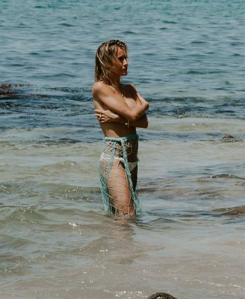 Kristin Cavallari Pictures Kristin Cavallari topless seen by paparazzi at the beach covering her nude boobs with her arms.