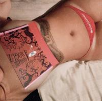 Bella Thorne nude in just thong panties with her book covering her topless boobs.










