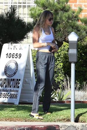 Miley Cyrus braless boobs in a slightly see through white top showing off her tits seen by paparazzi.
