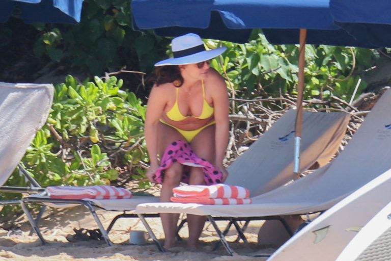 Britney Spears Bikini Pictures Britney Spears in a sexy little yellow bikini seen by paparazzi at the beach showing nice cleavage.