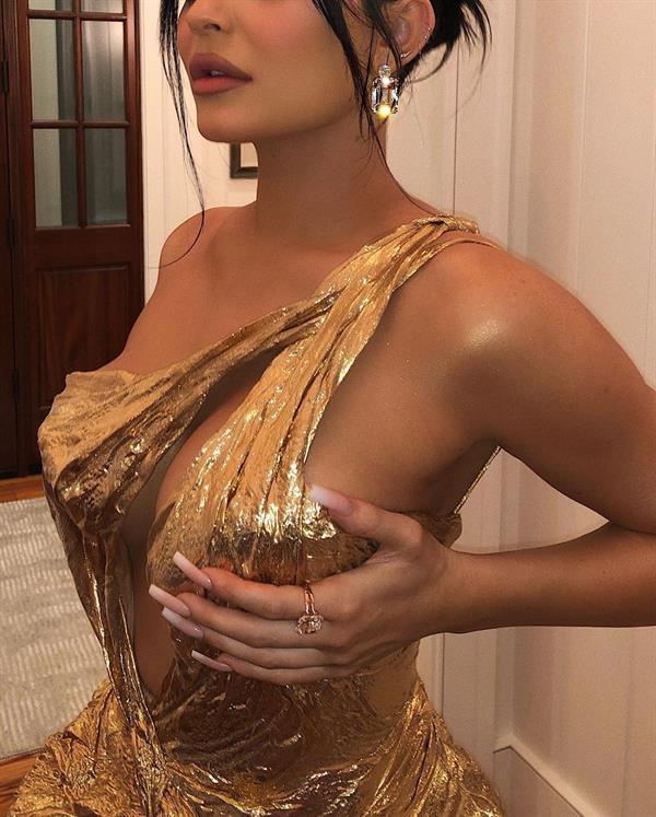 Kylie Jenner in sexy gold dress showing off her braless boobs cleavage going to Justin Bieber and Hailey Bieber's wedding.






































