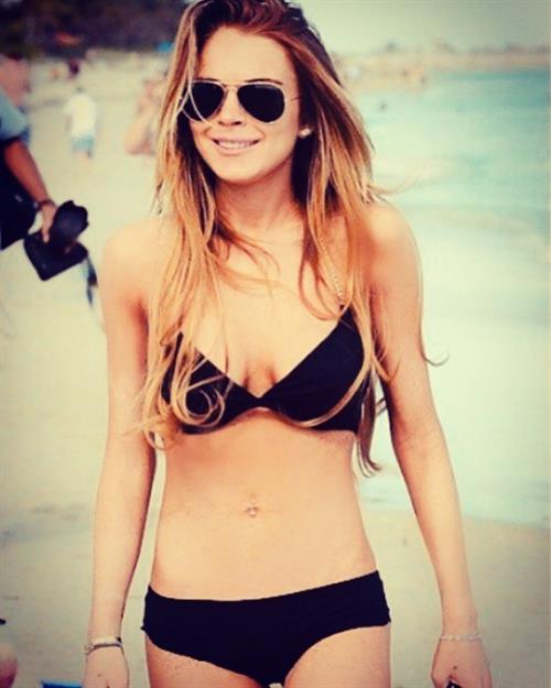Lindsay Lohan Bikini Pictures Lindsay Lohan shared a picture of her in a sexy bikini at the beach with her big tits showing nice cleavage.