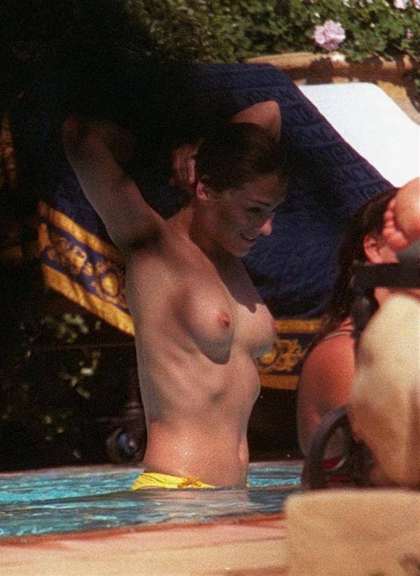 Elizabeth Hurley nude boobs caught topless by paparazzi in the pool showing off her tits wearing just bikini bottoms.