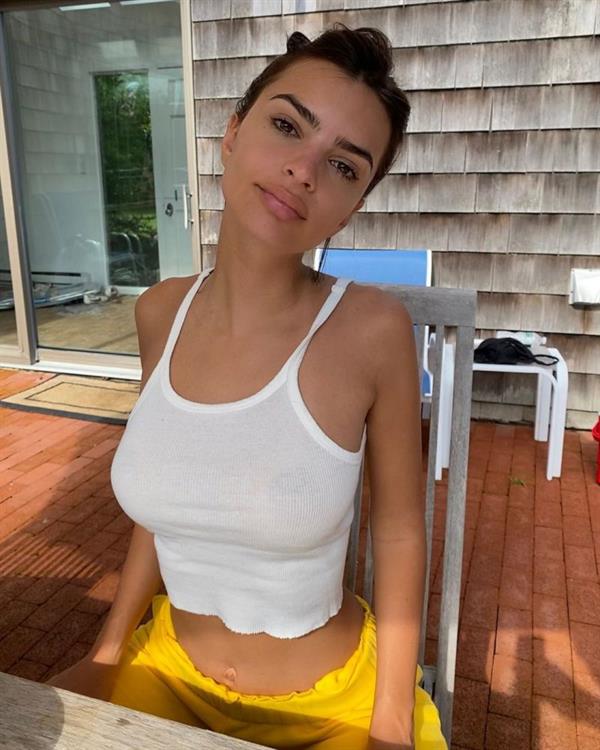Emily Ratajkowski braless boobs in a see through white tank top showing off her big tits sitting in her backyard.