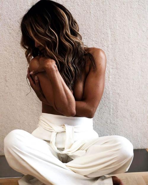 Halle Berry Pictures Halle Berry topless boobs new photo sitting cross legged covering her nude big tits with her arms.