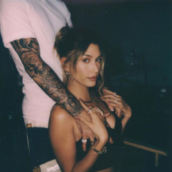 Justin Bieber standing behind his wife Hailey Bieber grabbing her big tits wearing a sexy little top.