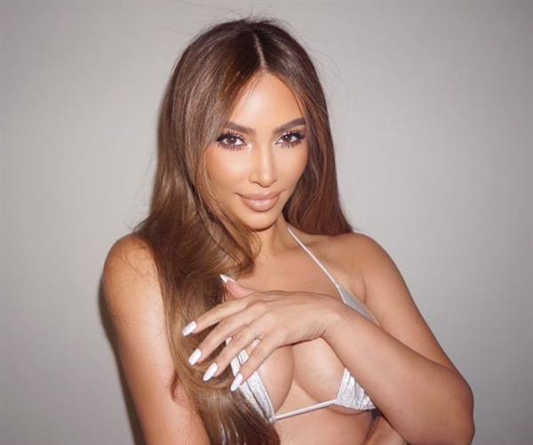 Kim Kardashian boobs showing nice cleavage with her big tits in a sexy bikini top promoting her kkw brand.