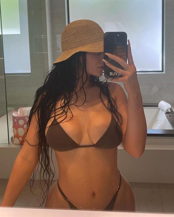 Kylie Jenner boobs showing nice cleavage with her big tits in a sexy thong bikini in her bathroom while spending the day by her pool.