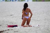 Claudia Romani in a purple thong bikini at the beach