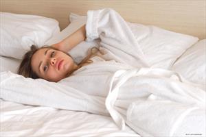 Anya posing on a bed