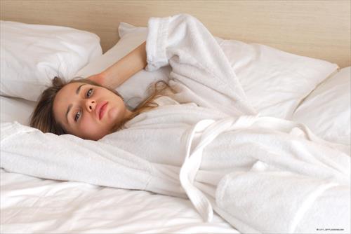 Anya posing on a bed